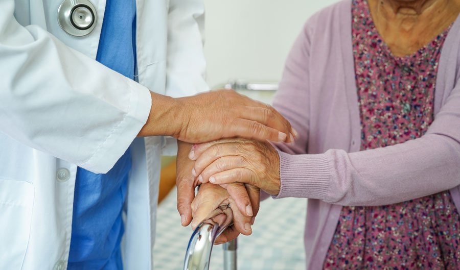 Doctor help Asian elderly woman disability patient walk with wal